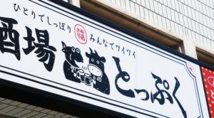 “大衆酒場とっぷくの横長看板”